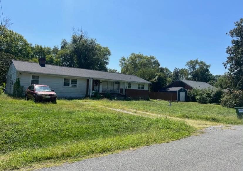 The ranch house before: overgrown lawn and worn siding